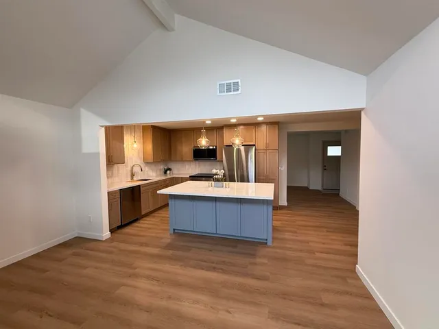a large room with a large kitchen counter space and a sink