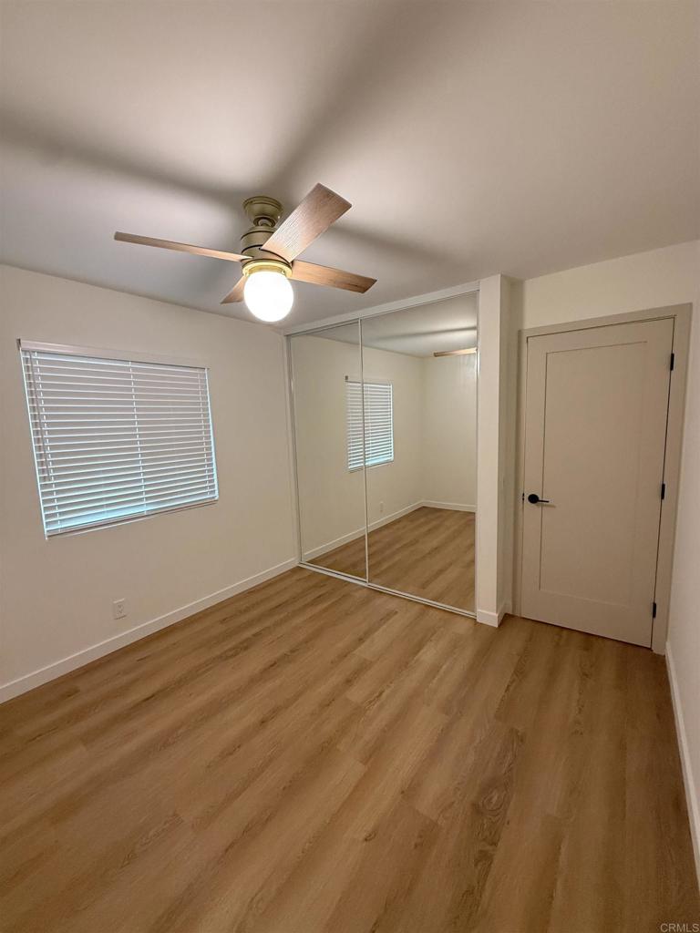 10296 Baroness Avenue San Diego, CA 92126 - Photo 4 of 27 an empty room with wooden floor fan and windows
