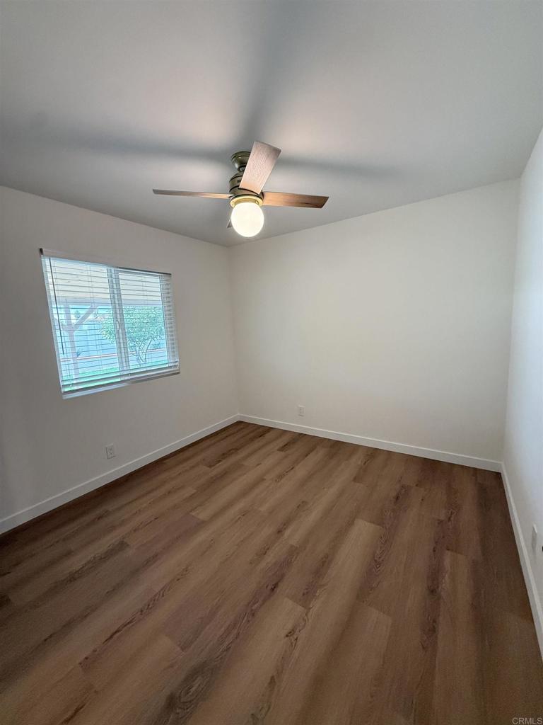 10296 Baroness Avenue San Diego, CA 92126 - Photo 6 of 27 a view of an empty room with window and wooden floor