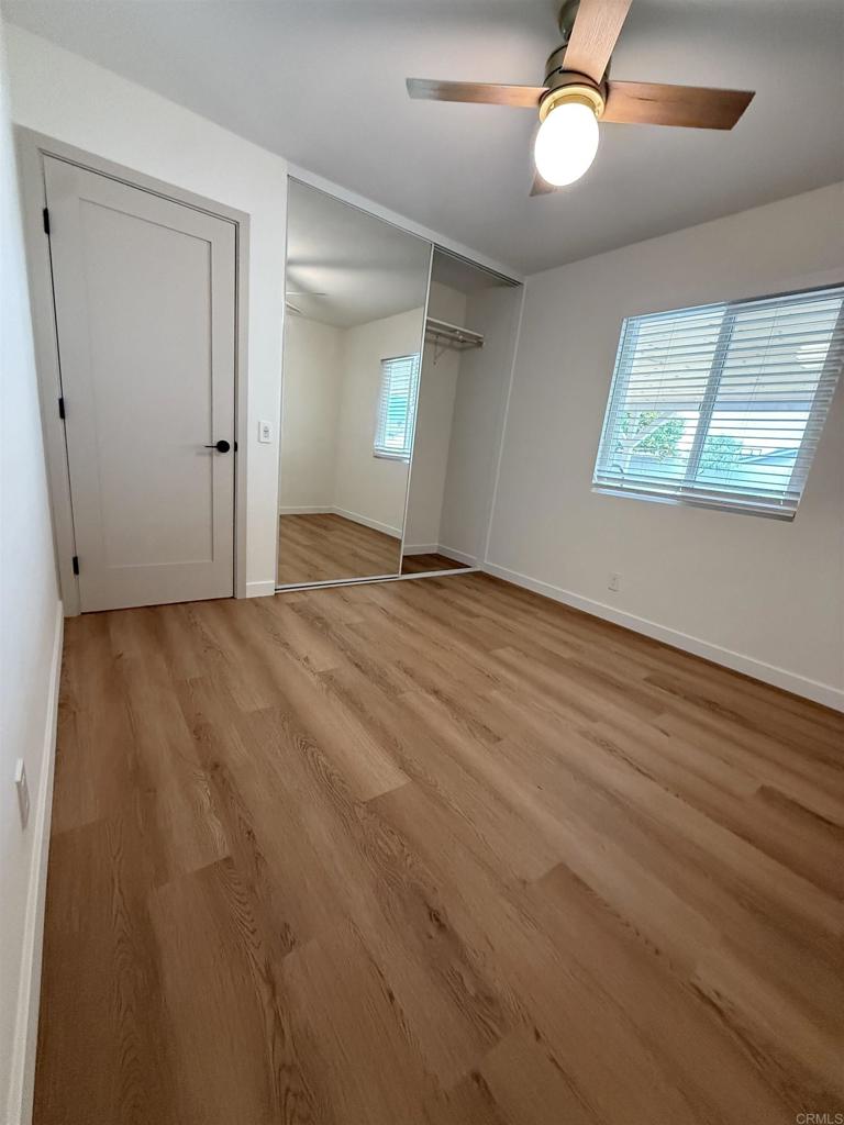 10296 Baroness Avenue San Diego, CA 92126 - Photo 7 of 27 an empty room with wooden floor fan and windows