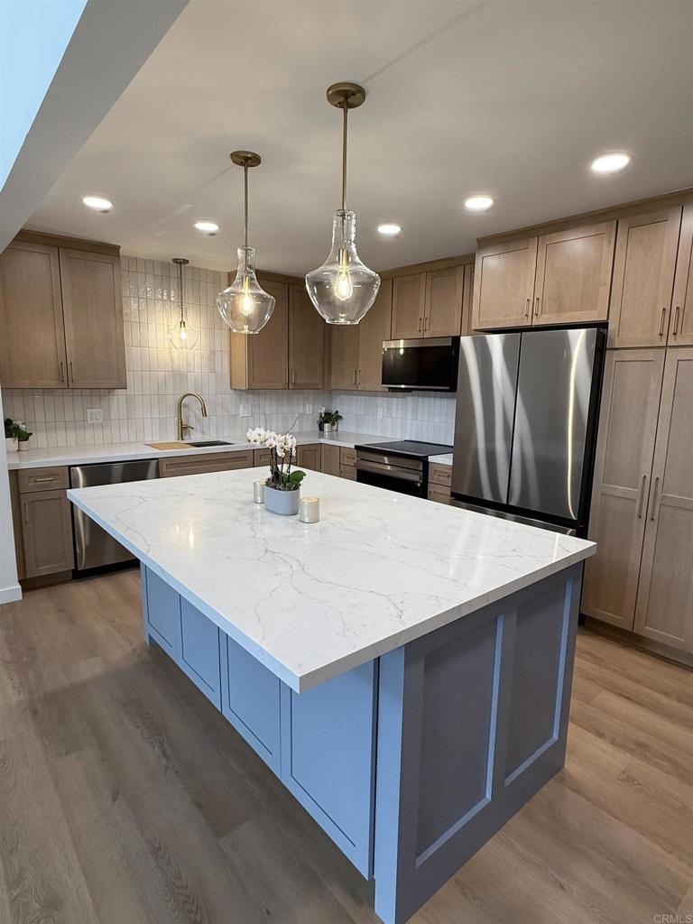 10296 Baroness Avenue San Diego, CA 92126 - Photo 9 of 27 a kitchen with kitchen island a sink a stove a refrigerator and island with wooden floor