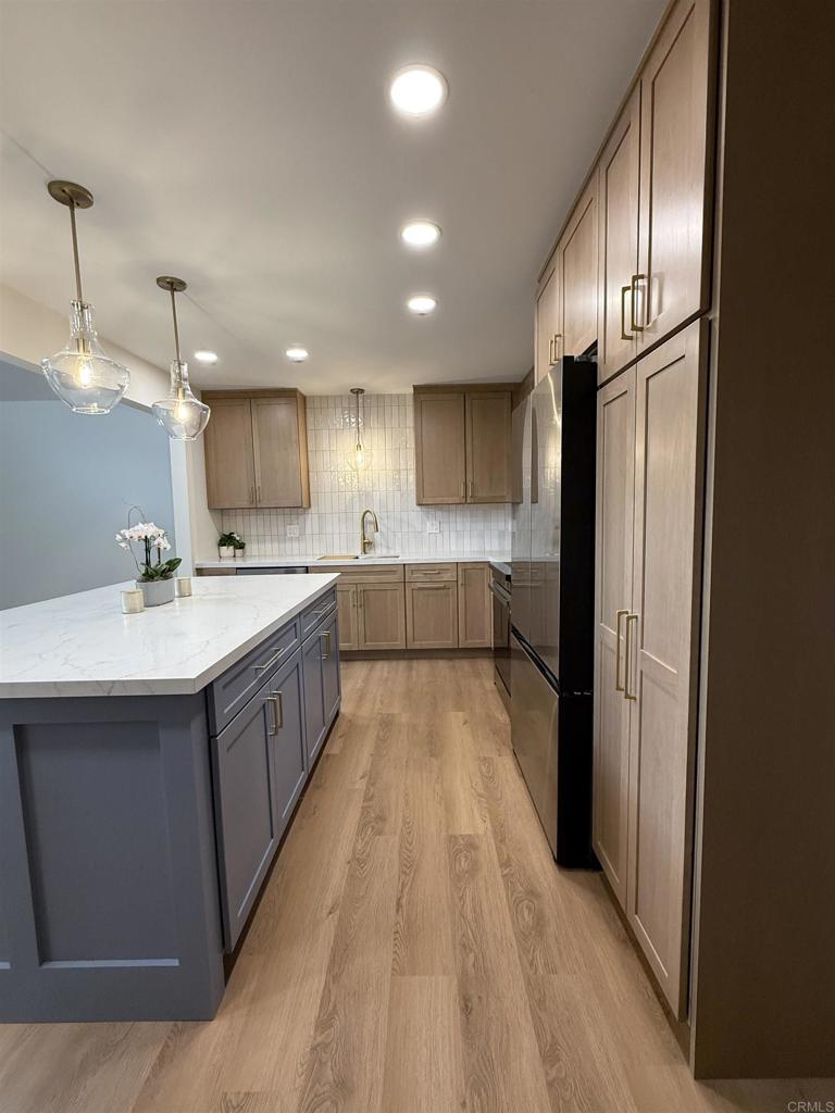 10296 Baroness Avenue San Diego, CA 92126 - Photo 10 of 27 a kitchen with kitchen island granite countertop wooden cabinets and sink
