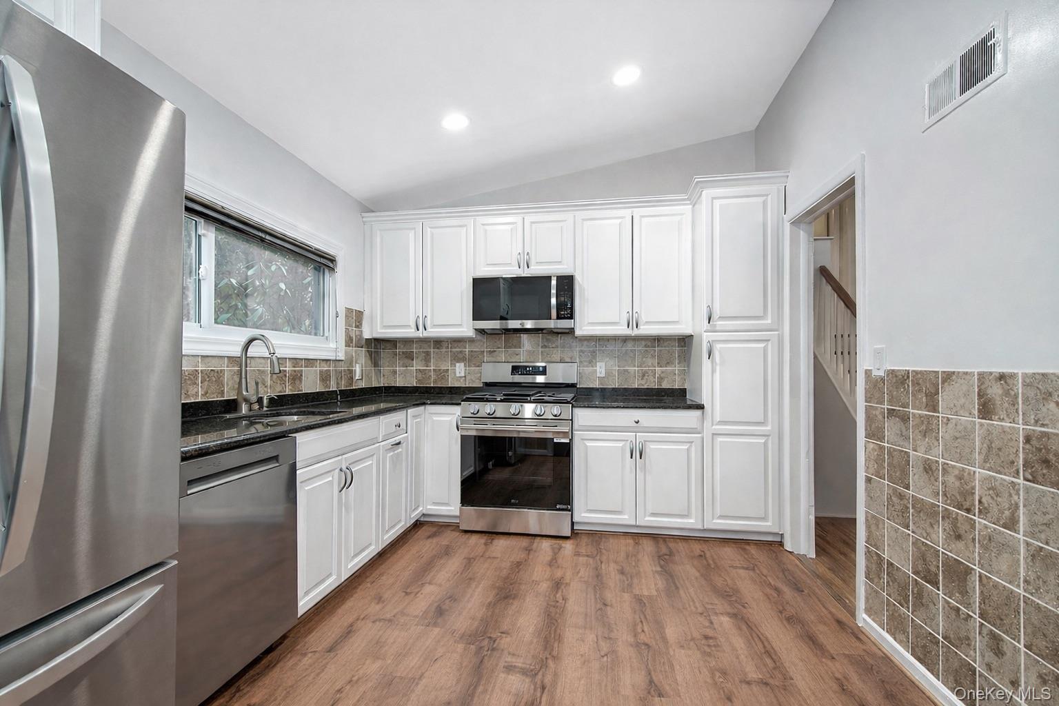 415 Pinebrook Boulevard New Rochelle, NY 10804 - Photo 10 of 20 a kitchen with granite countertop a stove top oven sink and cabinets