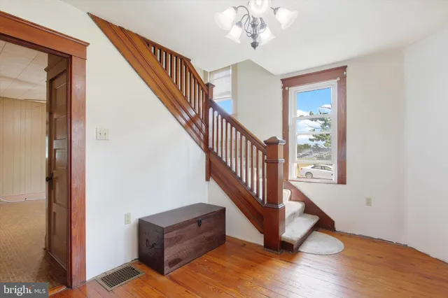 a view of a hallway with wooden floor and staircase