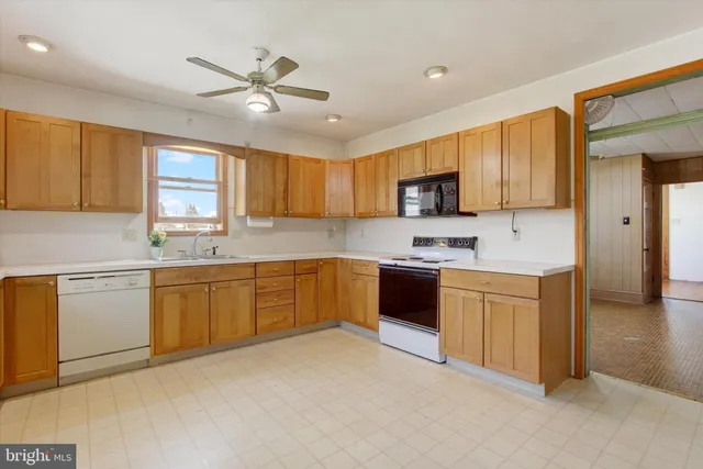 a kitchen with granite countertop a stove sink cabinets and window