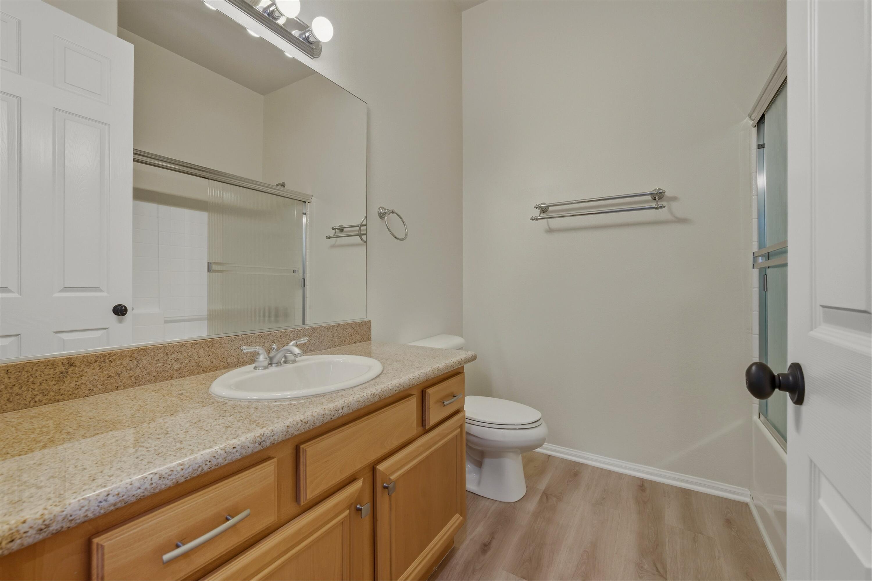49465 Lewis Road Indio, CA 92201 - Photo 25 of 31 a bathroom with a granite countertop sink a toilet and a mirror