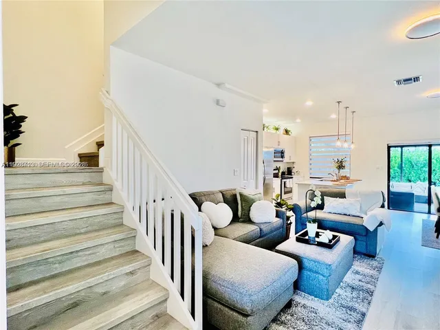 a living room with furniture and a chandelier