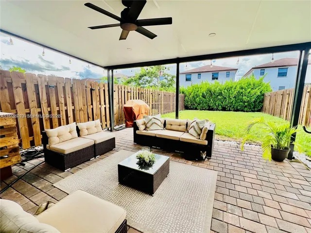 a living room with patio furniture and a potted plant