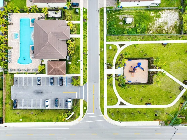 an aerial view of residential houses with outdoor space and swimming pool