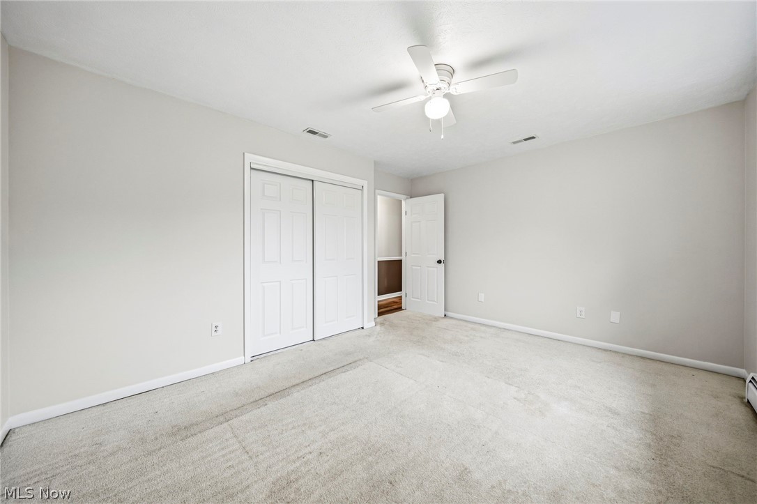 10397 Prouty Road Painesville, OH 44077 - Photo 12 of 32 Unfurnished bedroom with light carpet, a closet, and a ceiling fan