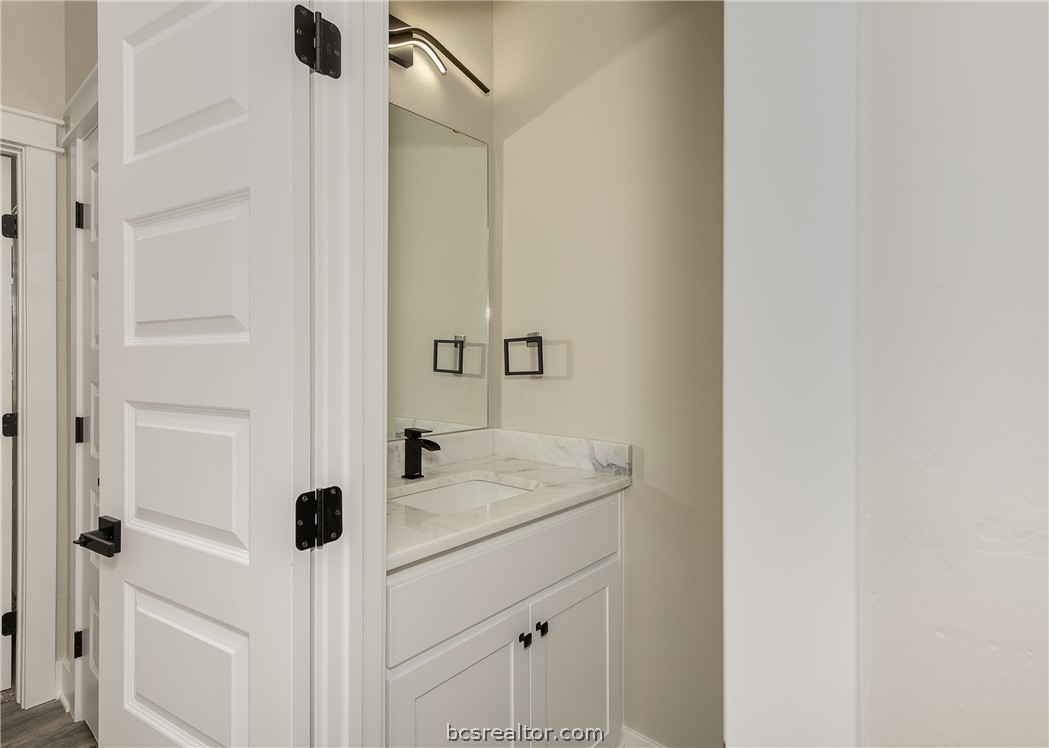 2908 GOLDBERG Drive Bryan, TX 77808 - Photo 11 of 44 Half bath features plate mirror, decorative light fixture, and quartz countertop.