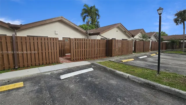 a view of a house with a small yard and wooden fence