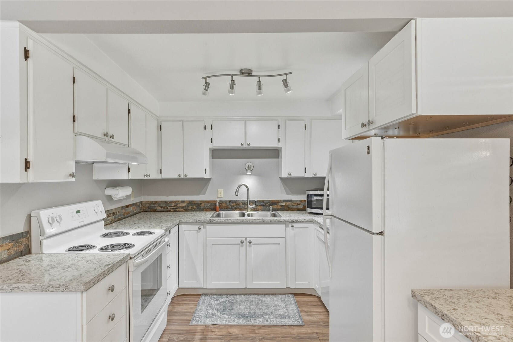369 East Birnie Slough Road Cathlamet, WA 98612 - Photo 12 of 31 a kitchen with a sink a stove a refrigerator and white cabinets