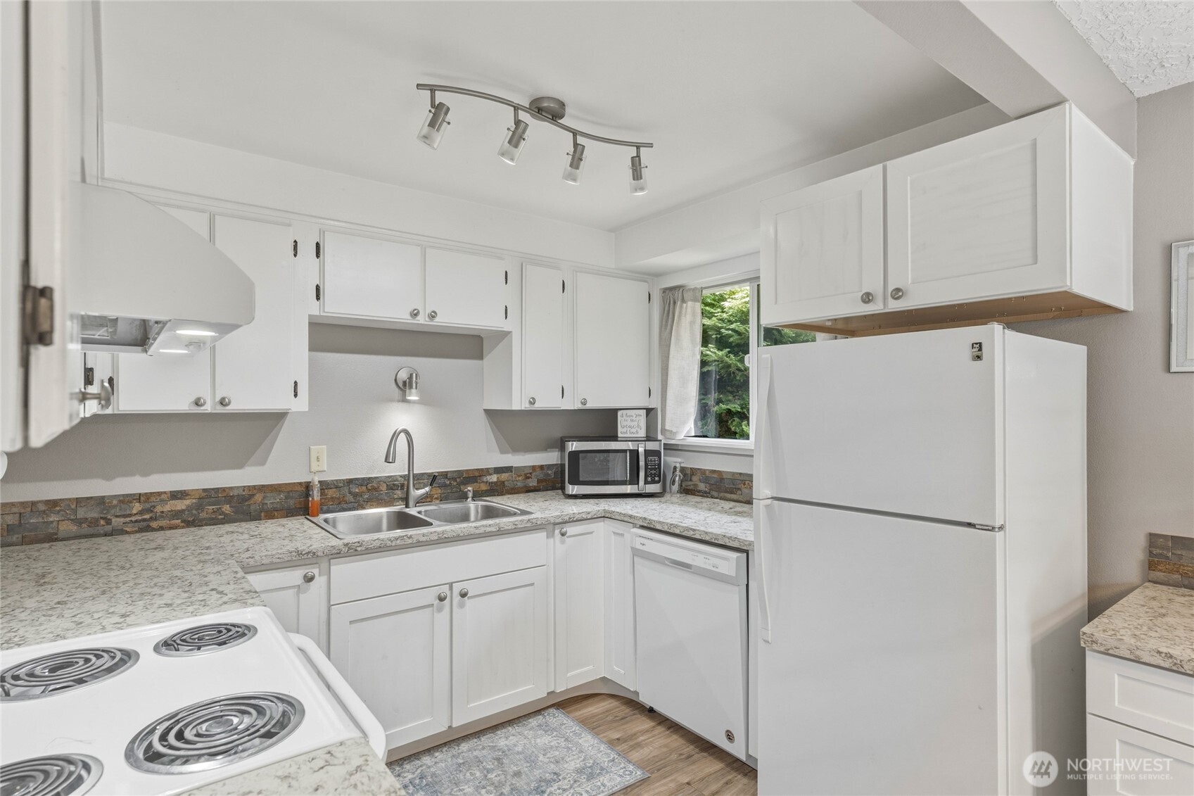 369 East Birnie Slough Road Cathlamet, WA 98612 - Photo 13 of 31 a kitchen with a sink a refrigerator and white cabinets