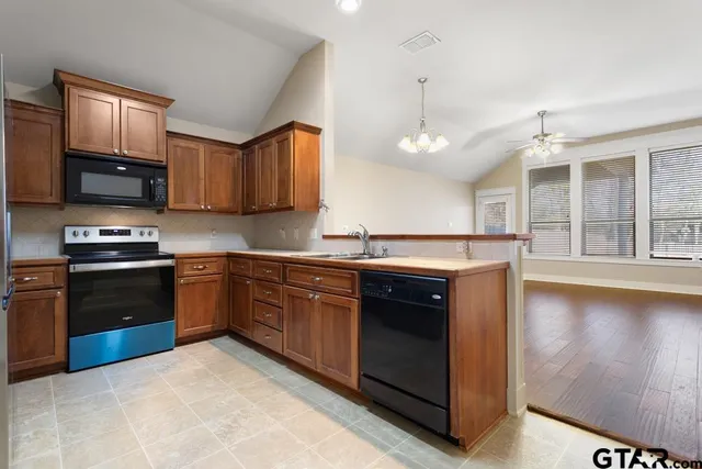 a kitchen with stainless steel appliances granite countertop a stove a sink and a microwave