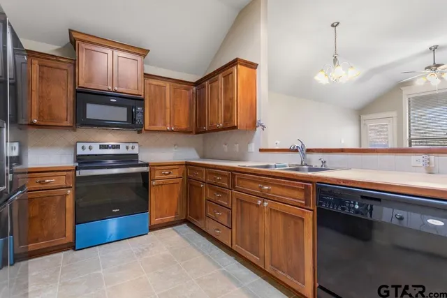 a kitchen with granite countertop wooden cabinets stainless steel appliances and a sink