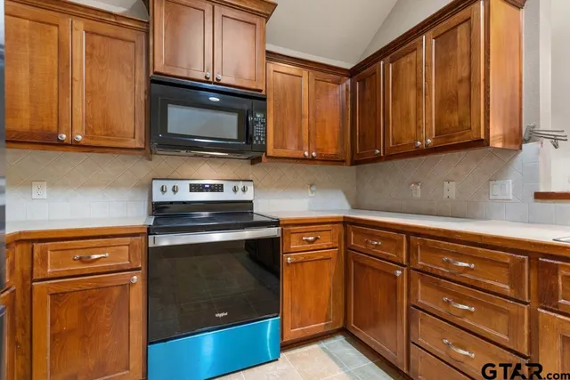 a kitchen with granite countertop wooden cabinets and stainless steel appliances