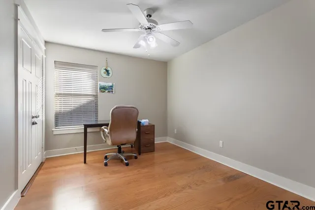 a view of a workspace with furniture and a window