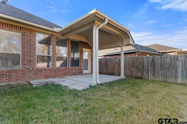 a view of a house with a yard and wooden fence