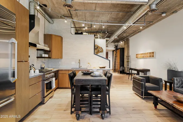 a kitchen with stainless steel appliances a sink dishwasher stove and oven with wooden floor