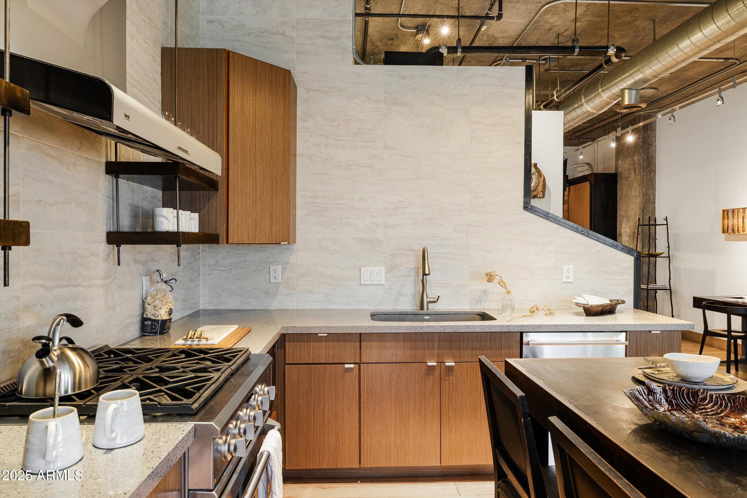 21 East 6th Street, Unit 507 Tempe, AZ 85281 - Photo 20 of 35 a kitchen with stainless steel appliances a sink dishwasher stove and oven with wooden floor