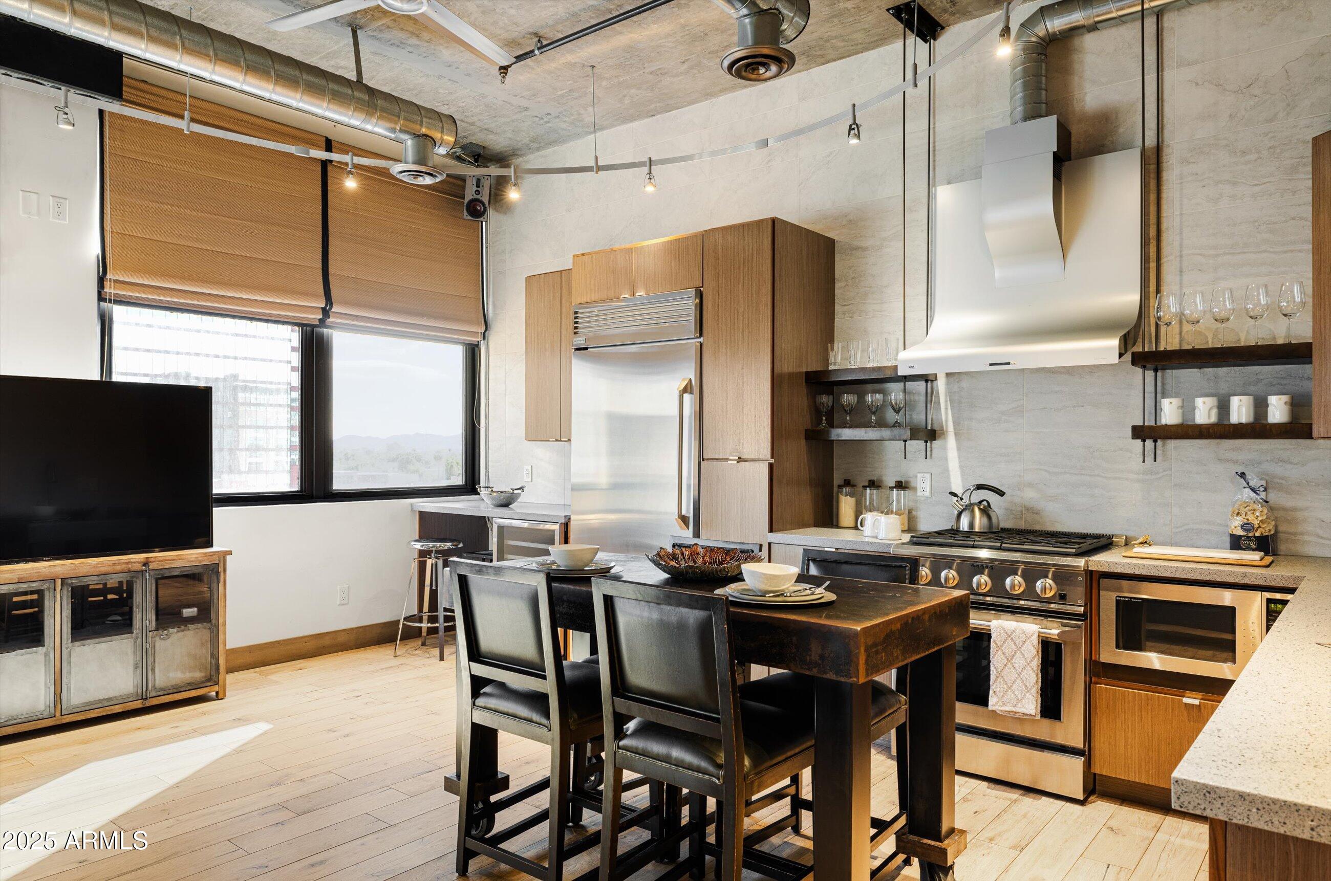 21 East 6th Street, Unit 507 Tempe, AZ 85281 - Photo 21 of 35 a kitchen with stainless steel appliances a table chairs and a window