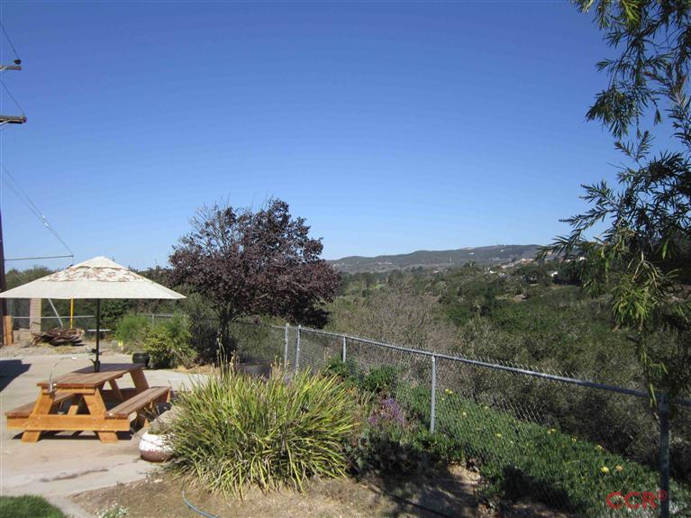 3901 Rigel Avenue Lompoc, CA 93436 - Photo 6 of 17 a backyard of a house with table and chairs under an umbrella