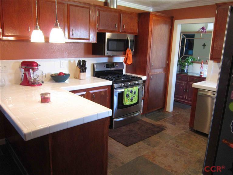 3901 Rigel Avenue Lompoc, CA 93436 - Photo 9 of 17 a kitchen with kitchen island a stove a sink and a refrigerator