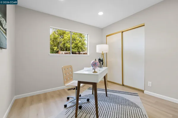 a view of a workspace with furniture and a window