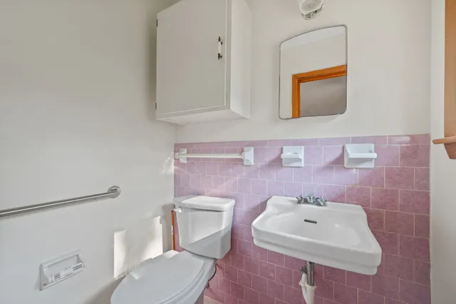 a bathroom with a sink mirror and toilet