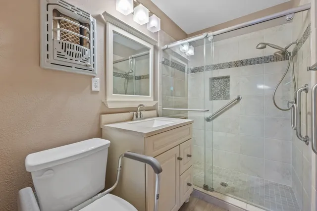 a bathroom with a granite countertop sink toilet and shower