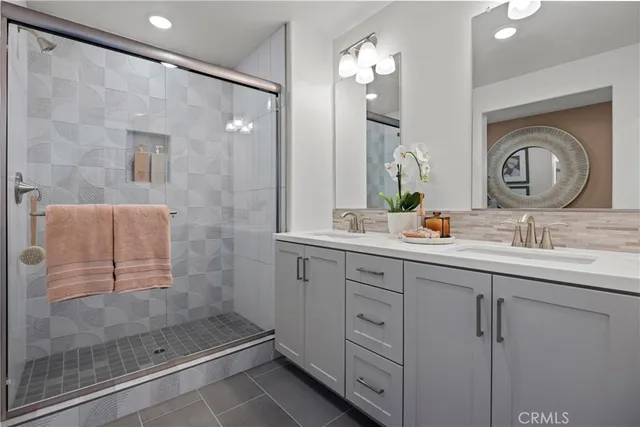 a bathroom with a double vanity sink mirror and shower