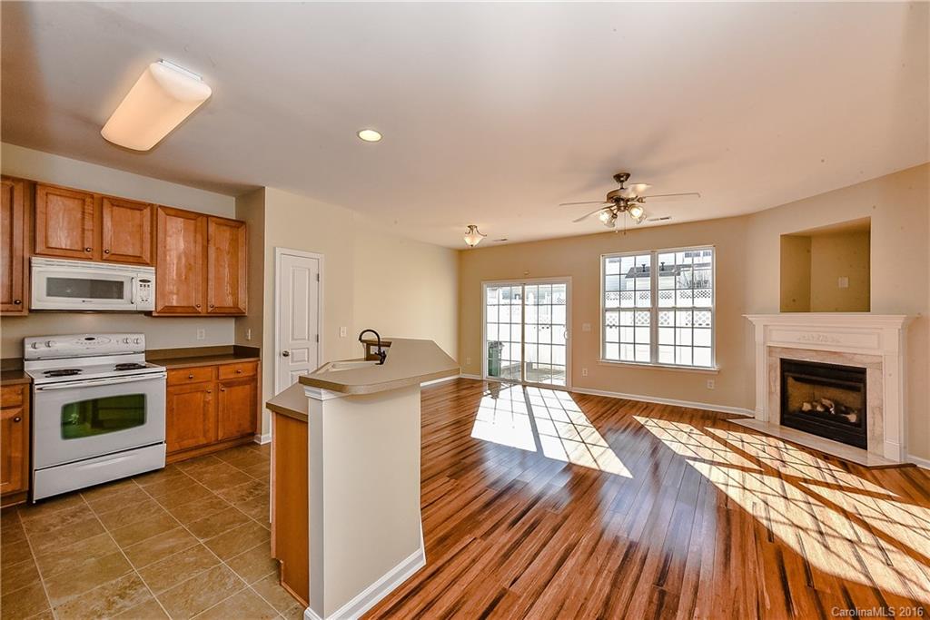 316 Sugar Ridge Court, Unit 95 Fort Mill, SC 29708 - Photo 6 of 23 a kitchen with stainless steel appliances granite countertop a stove top oven a sink dishwasher and a fireplace with wooden floor