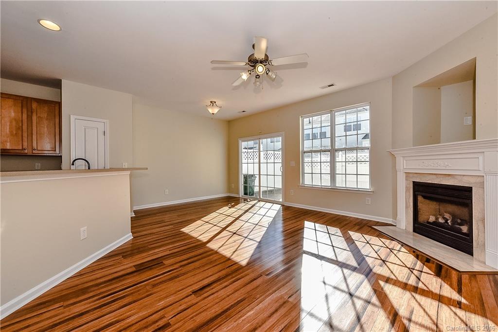 316 Sugar Ridge Court, Unit 95 Fort Mill, SC 29708 - Photo 8 of 23 a view of an empty room with wooden floor fireplace and a window