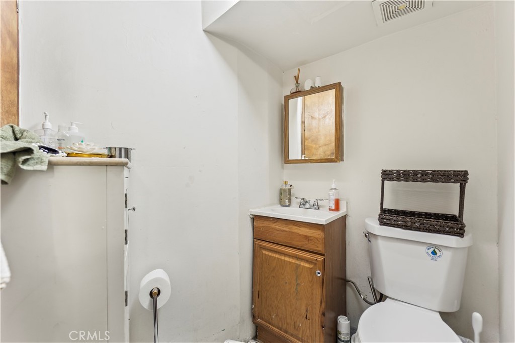 2424 West Boulevard Los Angeles, CA 90016 - Photo 15 of 21 a bathroom with a toilet a sink and mirror