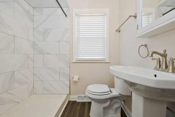 a bathroom with a sink a toilet and shower