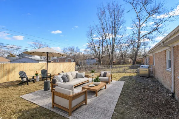 a view of a patio with couches and table under an umbrella