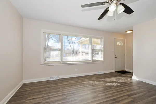a view of empty room with wooden floor and window