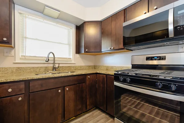 a kitchen with stainless steel appliances a sink stove and microwave