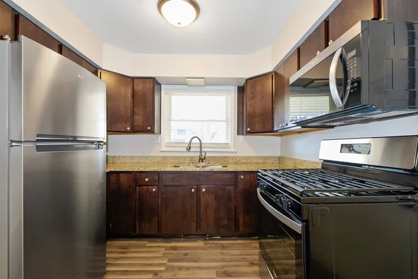 a kitchen with stainless steel appliances granite countertop a sink stove and refrigerator
