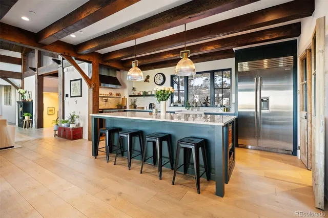 a dining hall with stainless steel appliances granite countertop a sink and a refrigerator