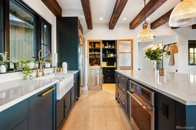 a large kitchen with stainless steel appliances a sink and a large window