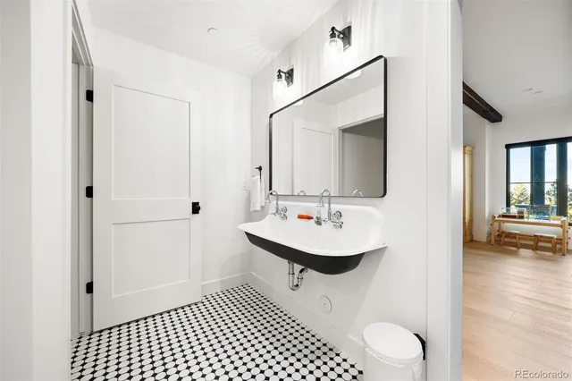 a bathroom with a sink a toilet and a mirror