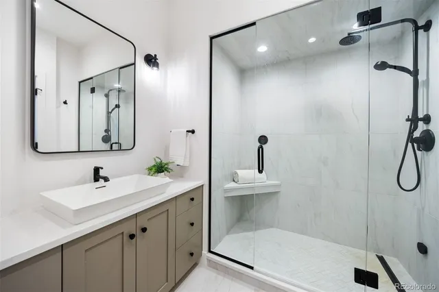 a bathroom with a shower sink and mirror
