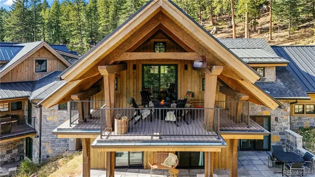 a front view of a house with glass windows and a table and chairs