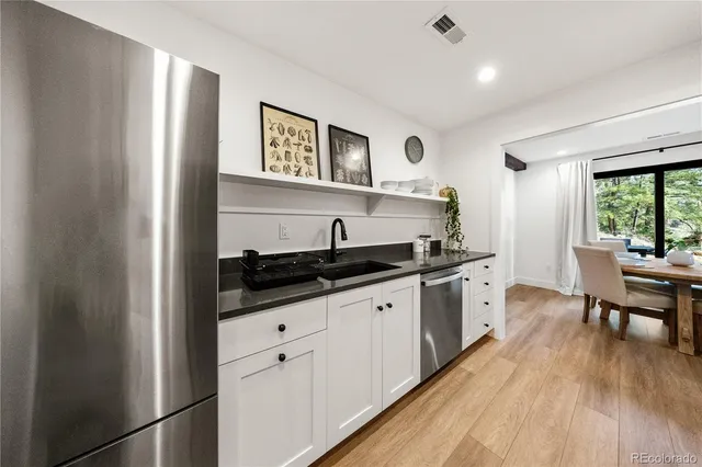 a kitchen with granite countertop a sink stove and cabinets