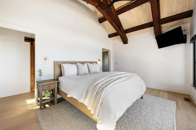 a bedroom with a bed and a flat screen tv