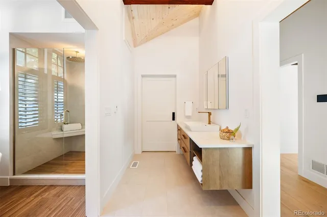 a bathroom with a sink a mirror and a shower