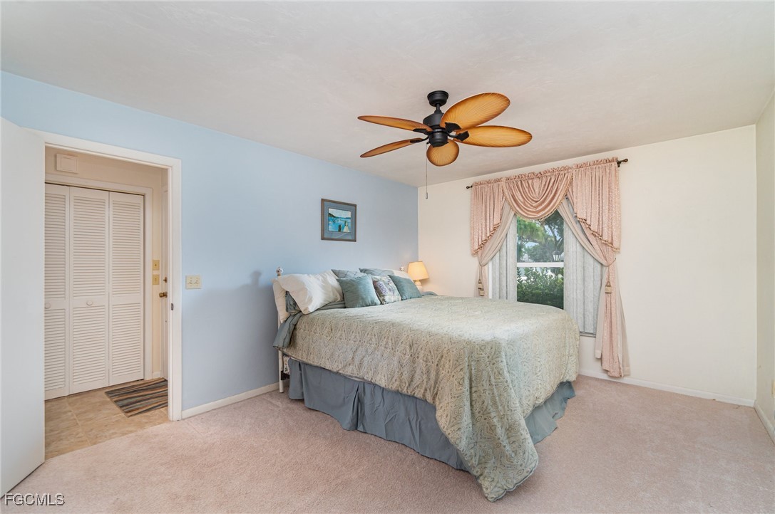 10615 Roxbury Court Lehigh Acres, FL 33936 - Photo 15 of 33 a bedroom with a bed a window and a chandelier