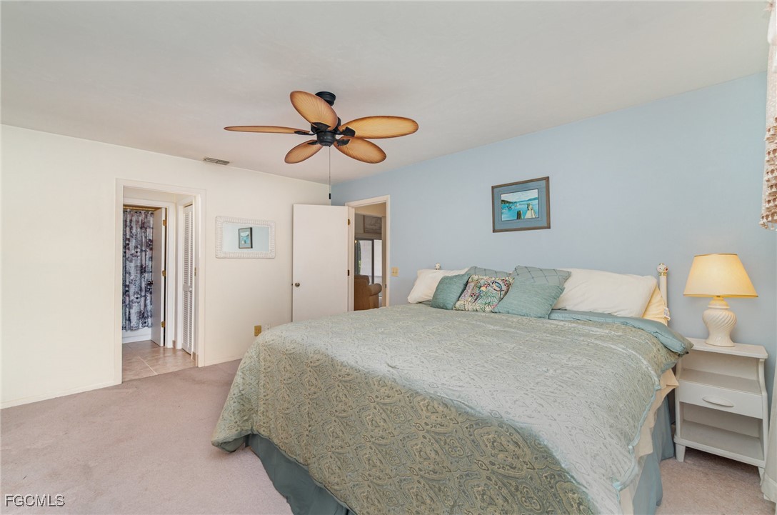 10615 Roxbury Court Lehigh Acres, FL 33936 - Photo 16 of 33 a bedroom with a bed and a chandelier